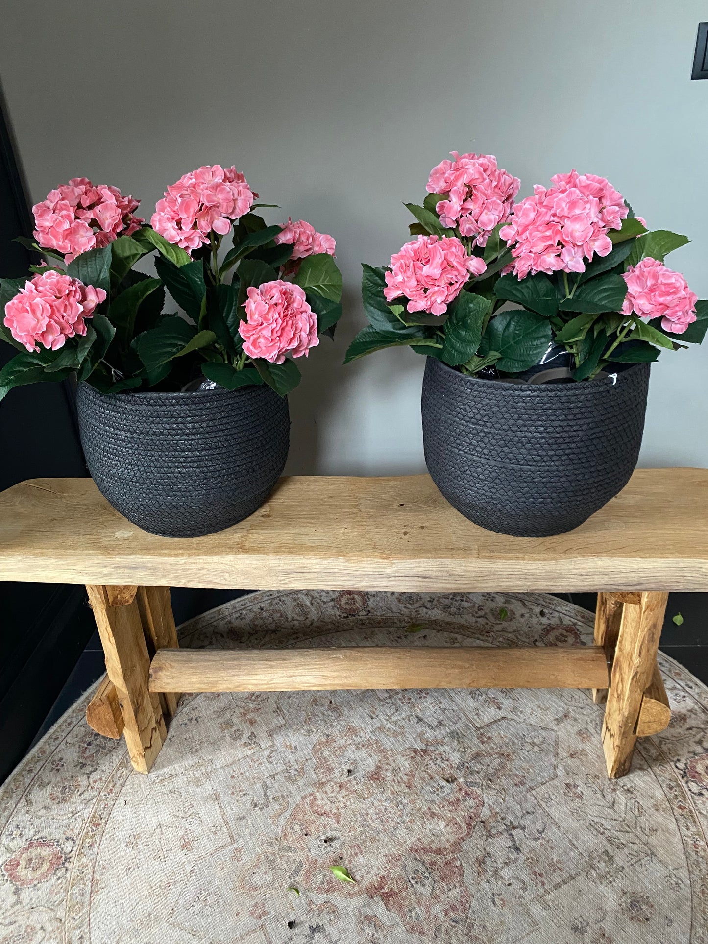 Roze zijdehortensia in zwarte mand